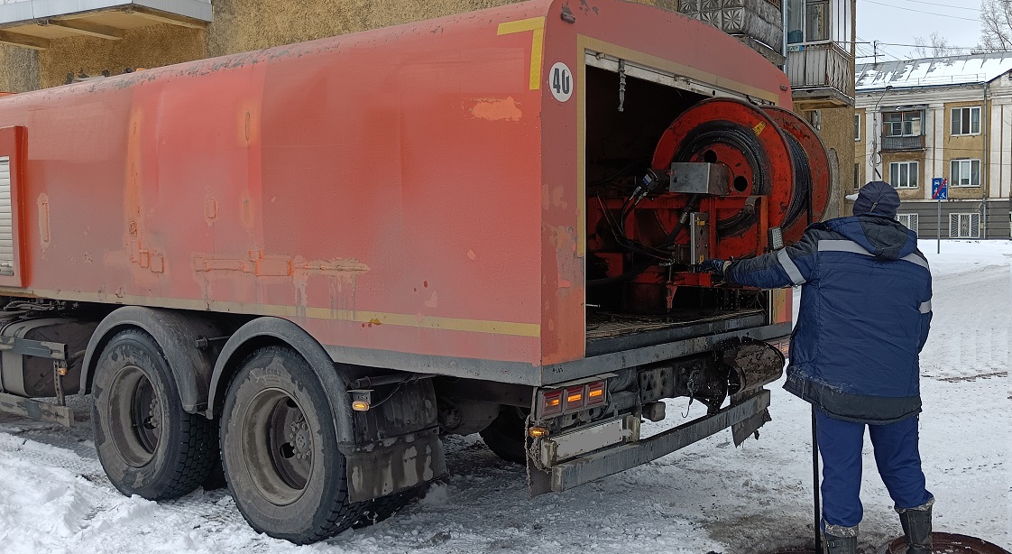 Каналопромывочная машина и работник прочищают засор в канализационной системе в Шумихе